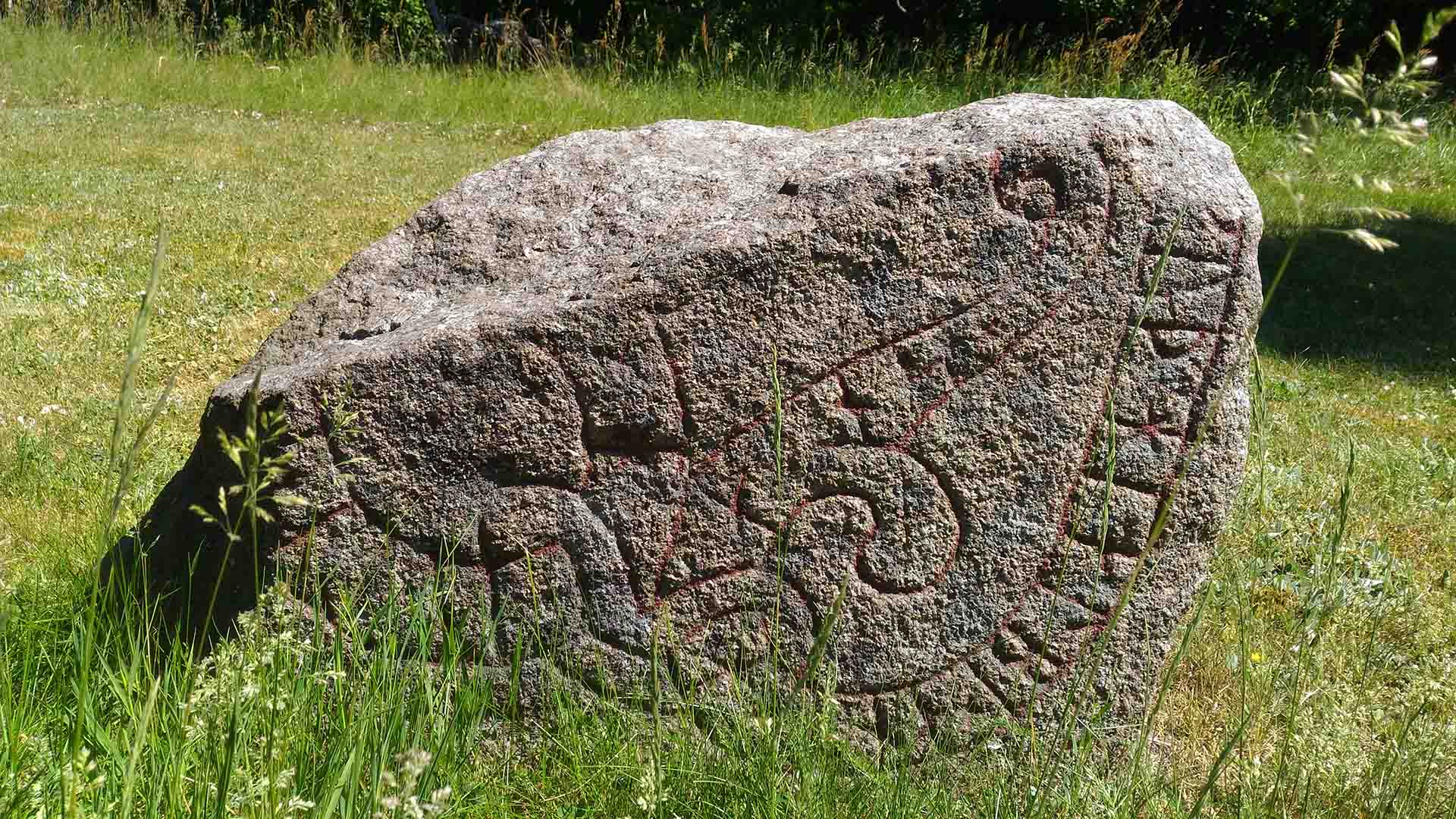 Cirka en meter bred sten med röd text.
