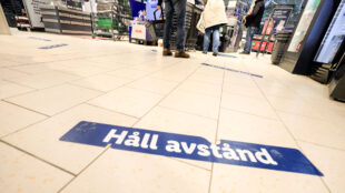 Mataffär med texten "Håll avstånd" på golvet.