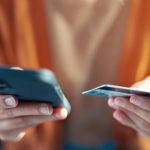 Kvinna i orange tröja betalar med kort i mobilen.