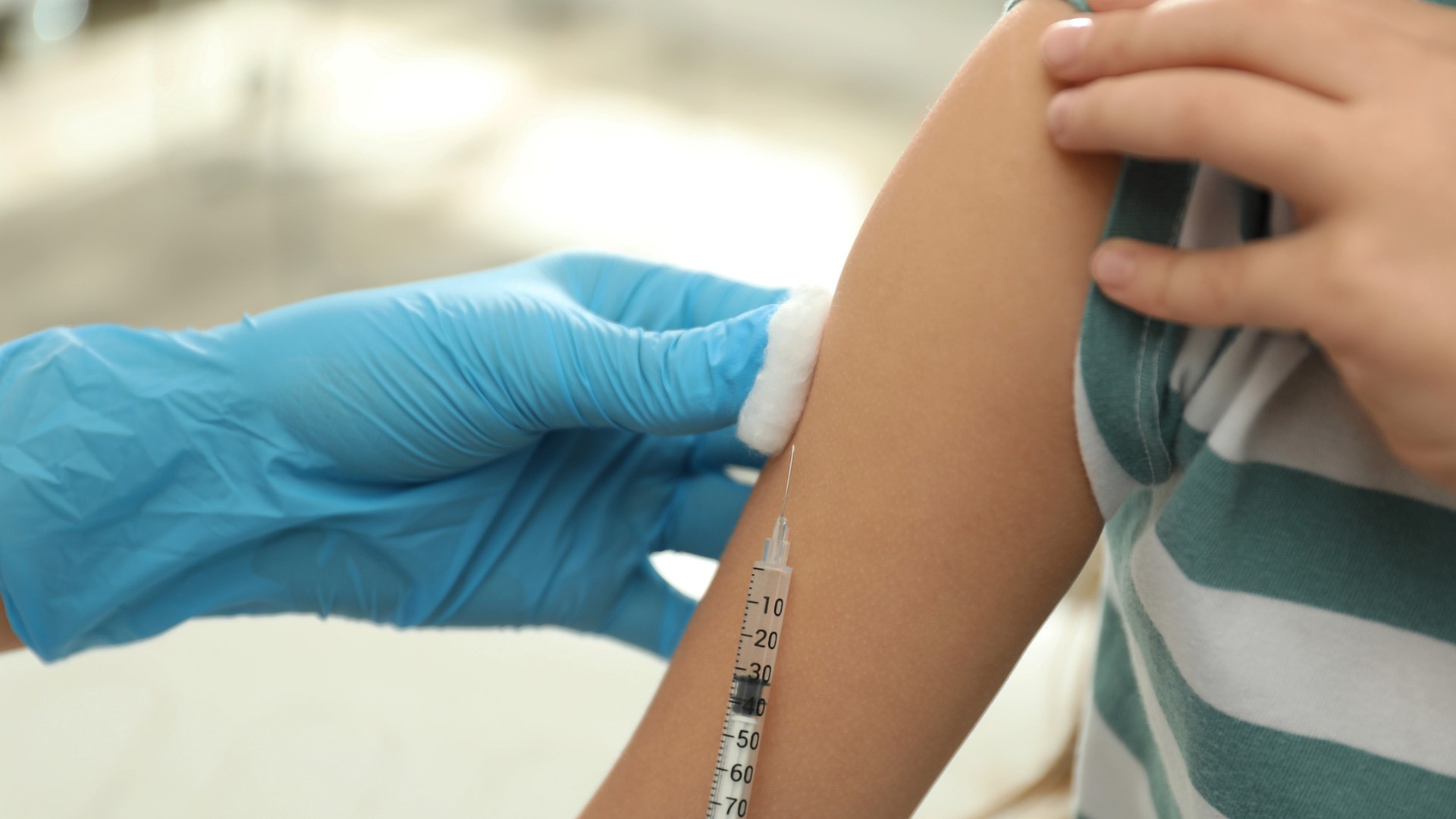 Pojke i randig tröja vaccineras